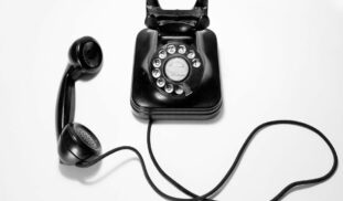 black rotary dial phone on white surface