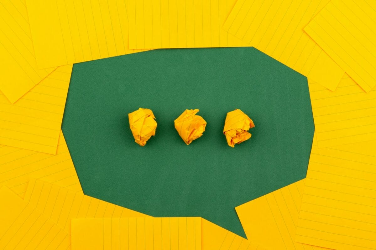 Photo by Volodymyr Hryshchenko three crumpled yellow papers on green surface surrounded by yellow lined papers