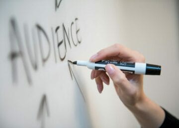 person holding white and blue click pen