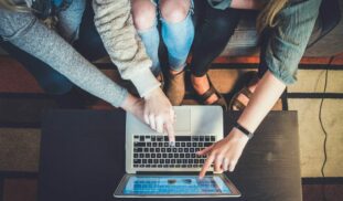 three person pointing the silver laptop computer