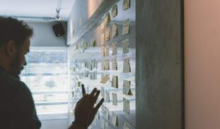 male putting sticky notes on wall