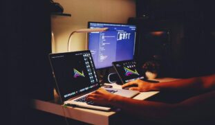 woman in black tank top sitting in front of computer
