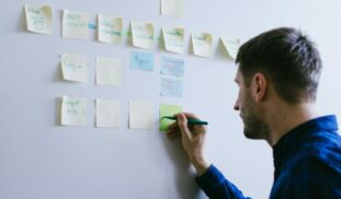 man in blue long sleeve shirt holding white smartphone
