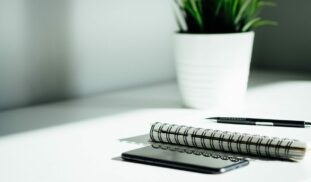 pen, notebook, and smartphone on table