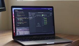 a laptop computer sitting on top of a wooden desk