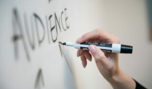 person holding white and blue click pen