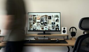 A blurry photo of a person standing in front of a computer