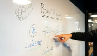 person writing on white board