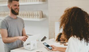 man in grey crew-neck t-shirt smiling to woman on counter