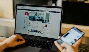 person using both laptop and smartphone