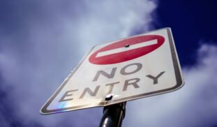 a no entry sign is shown against a blue sky